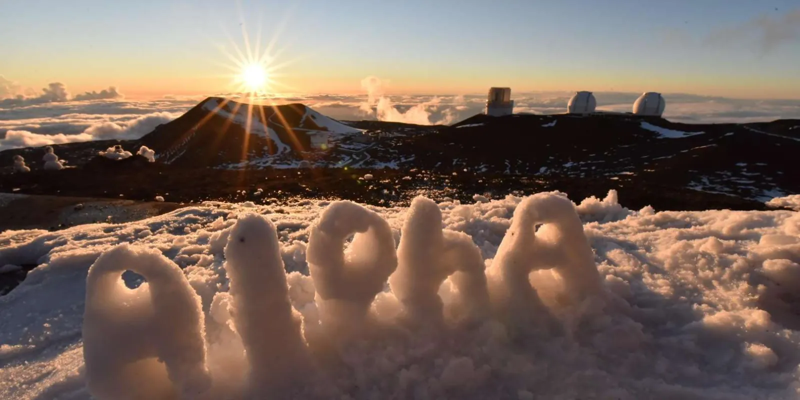 Telescopes set up on Mauna Kea summit plateau under a star-filled night sky
