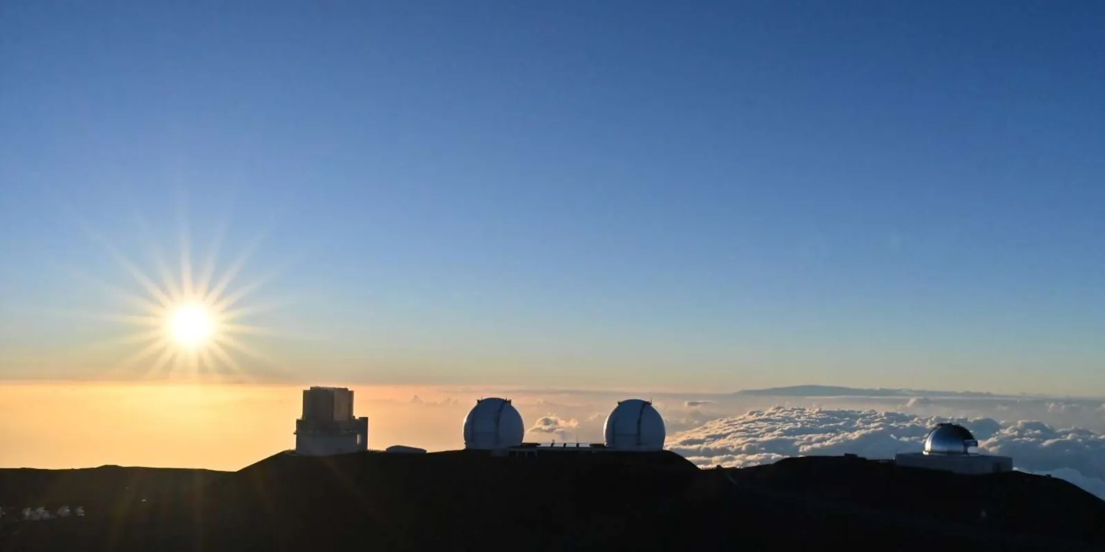 Guide pointing at the Milky Way over the Mauna Kea Observatory domes